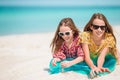 Little happy funny girls have a lot of fun at tropical beach playing together.