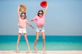 Little happy funny girls have a lot of fun at tropical beach playing together. Sunny day with rain in the sea Royalty Free Stock Photo