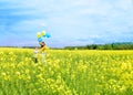 Little happy girl with blue and yellow .Yellow field of rapeseed. happy running kids. concept freedom, summer. Rapeseed Royalty Free Stock Photo