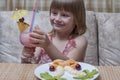 Little happy girl eating fruit salad and strawberry milkshake, closeup. Healthy food for children Royalty Free Stock Photo