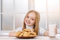 Little happy girl eats cookies and drinks milk. Royalty Free Stock Photo