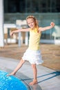 Little happy girl enjoy vacation near outdoor swimming pool Royalty Free Stock Photo