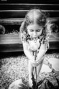 Little happy girl with a flower in her hands at the summer cottage in a pink t-shirt. Royalty Free Stock Photo