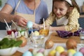 Little girl with grandmother dyeing Easter eggs
