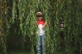 Little girl hiding in the willow foliage Royalty Free Stock Photo