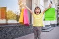 Little happy girl is holding colorful shopping bags Royalty Free Stock Photo