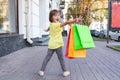 Little happy girl is holding colorful shopping bags Royalty Free Stock Photo