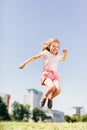 Little happy girl jumping high on the meadow. Royalty Free Stock Photo