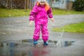 Little happy girl jumping in puddle Royalty Free Stock Photo