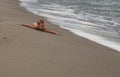 Little happy girl l;ying on sandy beach in Italy