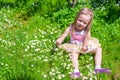 Little happy girl picking flowers in green glade Royalty Free Stock Photo