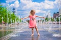 Little happy girl playing in open street fountain Royalty Free Stock Photo