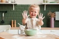 Little happy girl prepares dough in the kitchen. Hands in flour. Child pastry chef in the kitchen Royalty Free Stock Photo