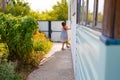 little happy girl running around the corner of a house in a summer village Royalty Free Stock Photo