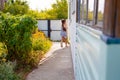 little happy girl running around the corner of a house in a summer village Royalty Free Stock Photo