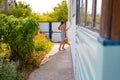 little happy girl running around the corner of a house in a summer village Royalty Free Stock Photo