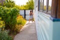 little happy girl running around the corner of a house in a summer village Royalty Free Stock Photo