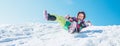 Little Happy girl slides down from the snow slope with blue sky