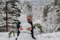 Little happy girl with snowman in winter snowy Park Royalty Free Stock Photo