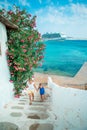 Little happy girls in dresses at street of typical greek traditional village on Mykonos Island, in Greece Royalty Free Stock Photo