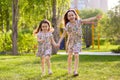 Little happy girls on a walk on a summer evening at sunset in the park. Sisters Royalty Free Stock Photo