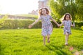 Little happy girls on a walk on a summer evening at sunset in the park. Sisters Royalty Free Stock Photo
