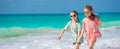 Little happy kids having a lot of fun at tropical beach playing together. Adorable girls dancing on caribbean island Royalty Free Stock Photo