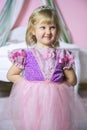 Little happy princess girl in pink dress and crown in her royal room posing and smiling. Royalty Free Stock Photo