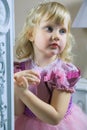 Little happy princess girl in pink dress and crown in her royal room posing and smiling. Royalty Free Stock Photo