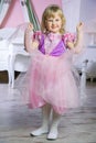 Little happy princess girl in pink dress and crown in her royal room posing and smiling. Royalty Free Stock Photo