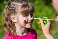Little happy sisters play with colors in the park, children play, children paint each other Royalty Free Stock Photo