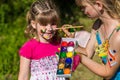 Little happy sisters play with colors in the park, children play, children paint each other Royalty Free Stock Photo