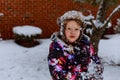 Little happy smiling girl in pink throws snowin the air with snawflakes flying Royalty Free Stock Photo