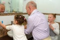 Little happy toddler girls and grandfather in bathroom washing hands.