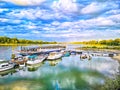 Little Harbour at the riverside of the river Rhein in Cologne with sky and sunlight reflections and boats in the water