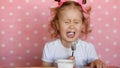 A little harmful girl refuses to eat and cries. The concept of raising children. Childhood and children`s hysteria