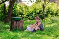 Little helper girl washes clothes using the washboard outdoors