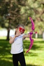 Little hero. Child girl in a mask shoots a toy bow and pretends to be an archer Royalty Free Stock Photo