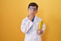 Little hispanic boy wearing scientist glasses covering mouth with hand, shocked and afraid for mistake