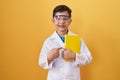 Little hispanic boy wearing scientist glasses smiling happy pointing with hand and finger