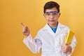 Little hispanic boy wearing scientist glasses smiling happy pointing with hand and finger to the side