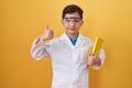 Little hispanic boy wearing scientist glasses smiling happy and positive, thumb up doing excellent and approval sign
