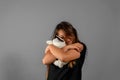 Little Hispanic girl picking up her stuffed dog and cuddles because she loves him very much. Isolated on gray studio Royalty Free Stock Photo