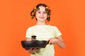 Little homemaker holding pan with ready meal. kid daily routine small girl making domestic work. girl with curlers in