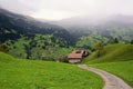 Little house and the green field with the mountain as background in the rainy day. Grindelwald, Switzerland Royalty Free Stock Photo