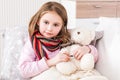 Little ill girl measuring teddy bear`s temperature Royalty Free Stock Photo