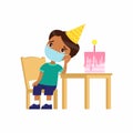 Little indian boy is sad on her birthday. Cute kid with a medical mask on his face sits on a chair.