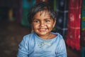 A little Indian girl looks at the camera and smiles at the photographer. Chocolate baby. Indian child in old clothes. Portrait of Royalty Free Stock Photo