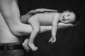 Little infant baby boy sleeping laying on fathers arms, an