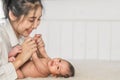 Little infant baby lying on bed with happy face mother holding hand Royalty Free Stock Photo